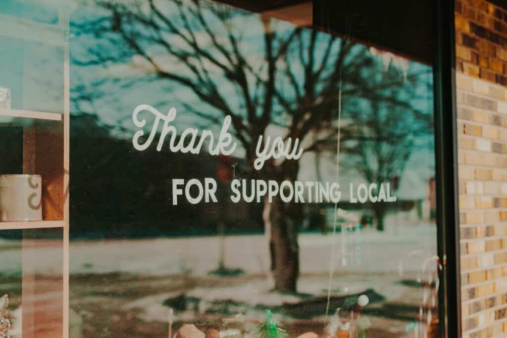 Window sign reading thank you for supporting local, relevant to attracting nearby customers